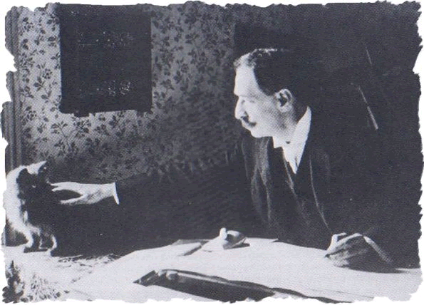 Louis Wain taking time to stroke one of his cats